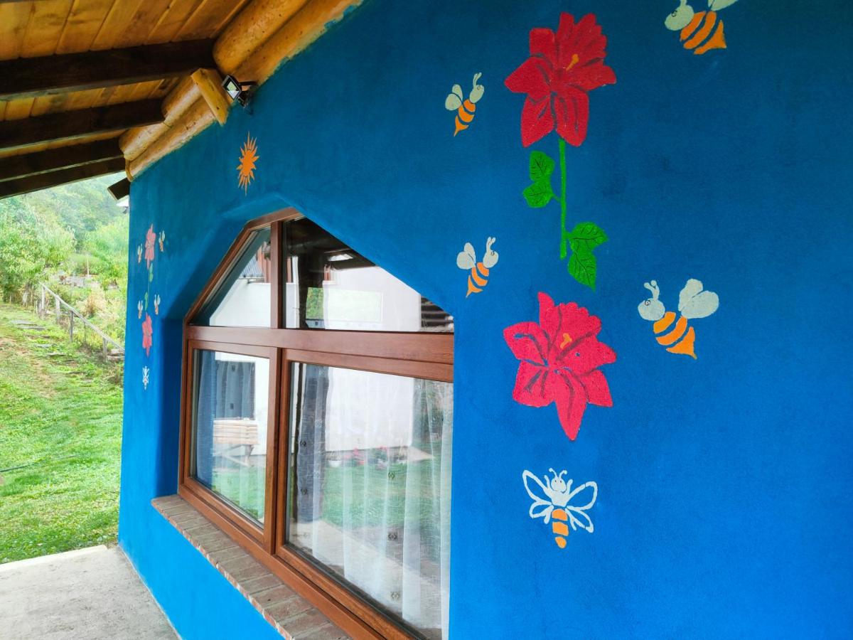Peretele casei pictat cu flori și albine